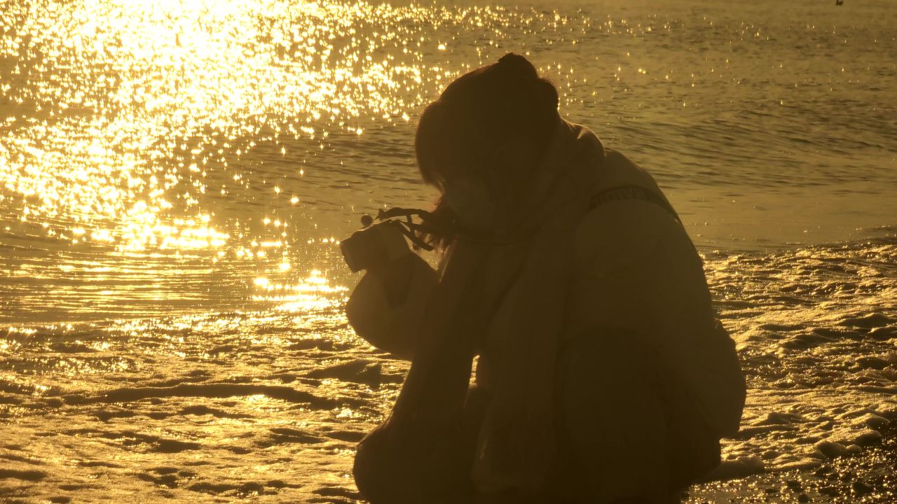 美女在海滩拍照