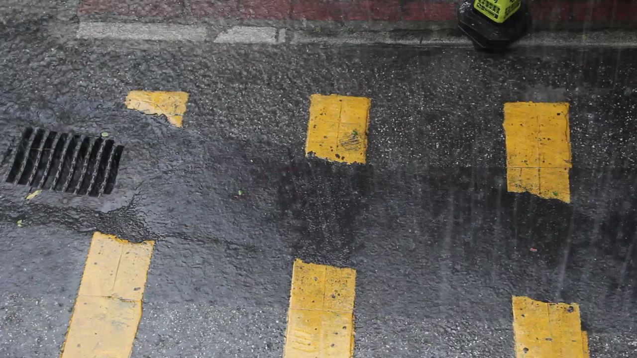 大雨中的沥青路面和雨水井