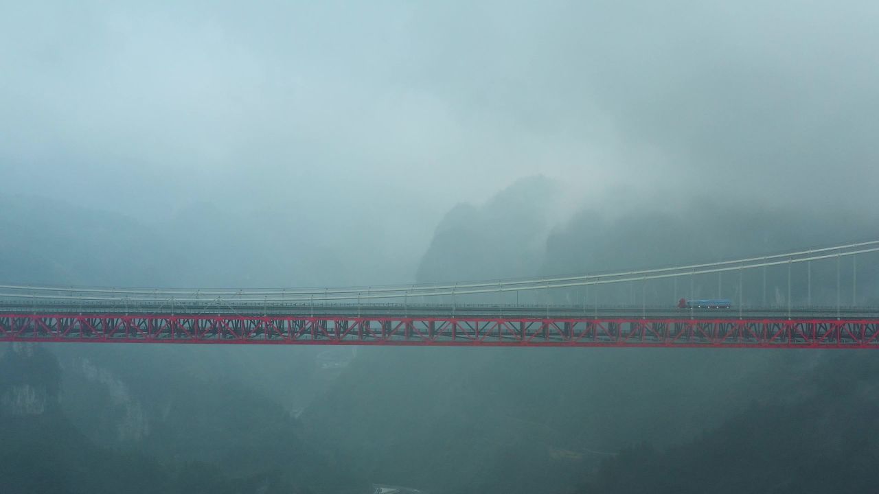 航拍雨后货车行驶在矮寨大桥上