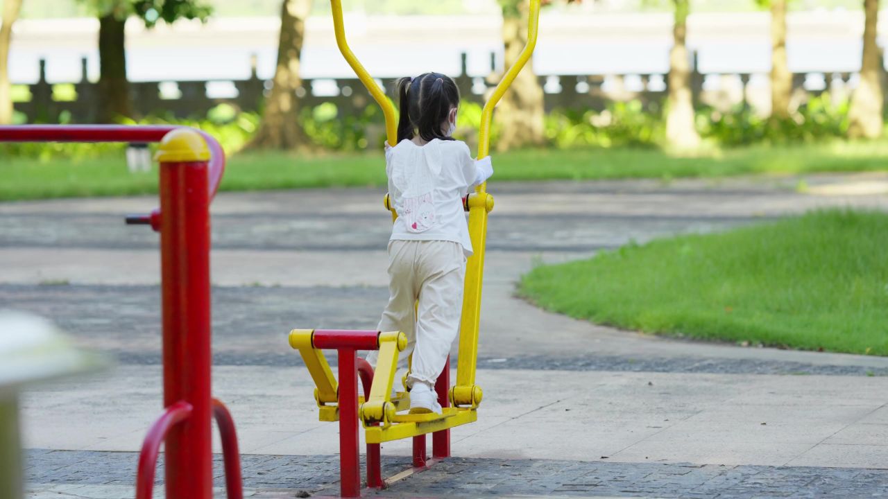 小孩子在公园玩健身器材