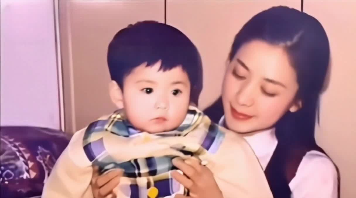 一个小孩的头歪着，靠近一位女人的脸。女人面带微笑，