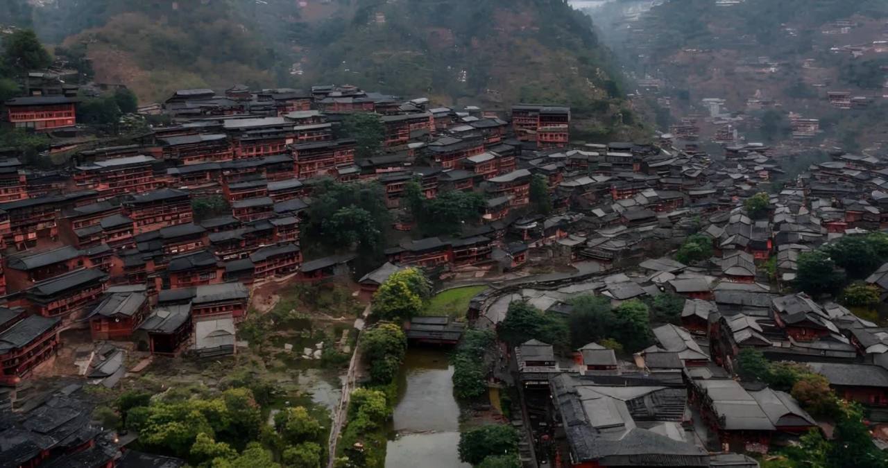 航拍视角下，许多房屋密集地分布在山坡上。房屋多为深