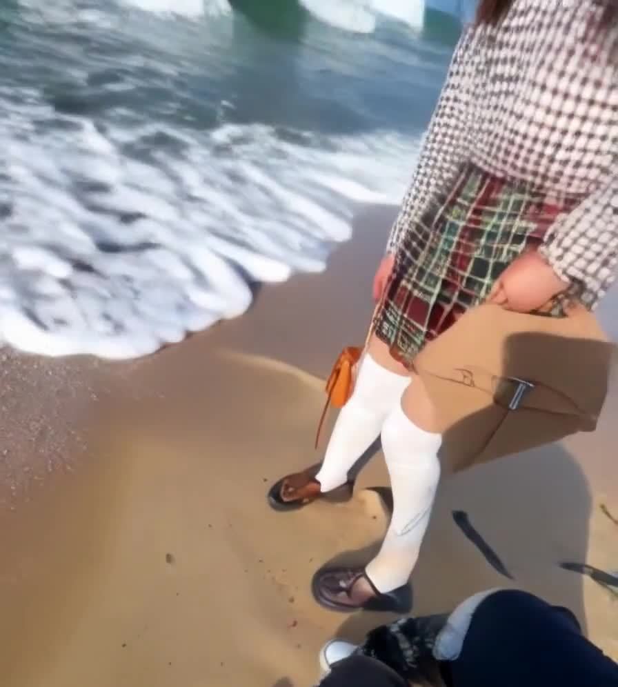海滩浸湿的鞋子与棕色皮包和格纹裤子