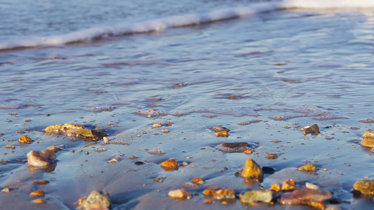 海滩晨曦：海浪轻抚石滩