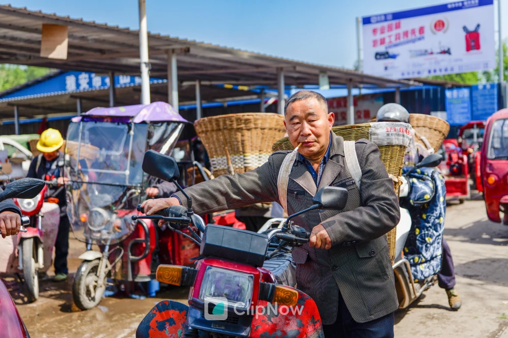 乡村集市背竹筐骑摩托车的中年男子纪实摄影