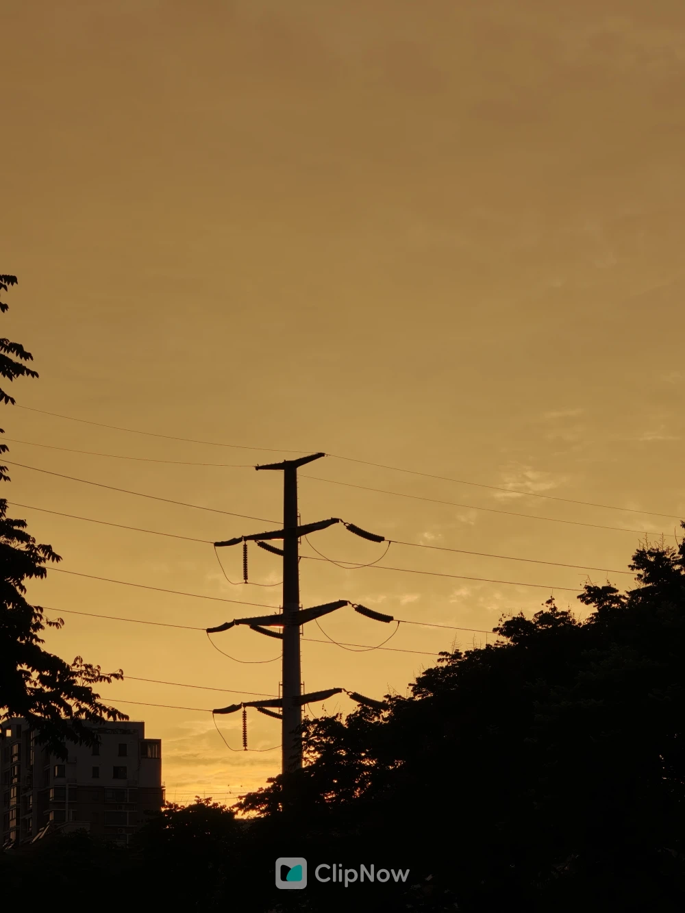 黄昏夕阳下的高压输电塔剪影与城市天际线
