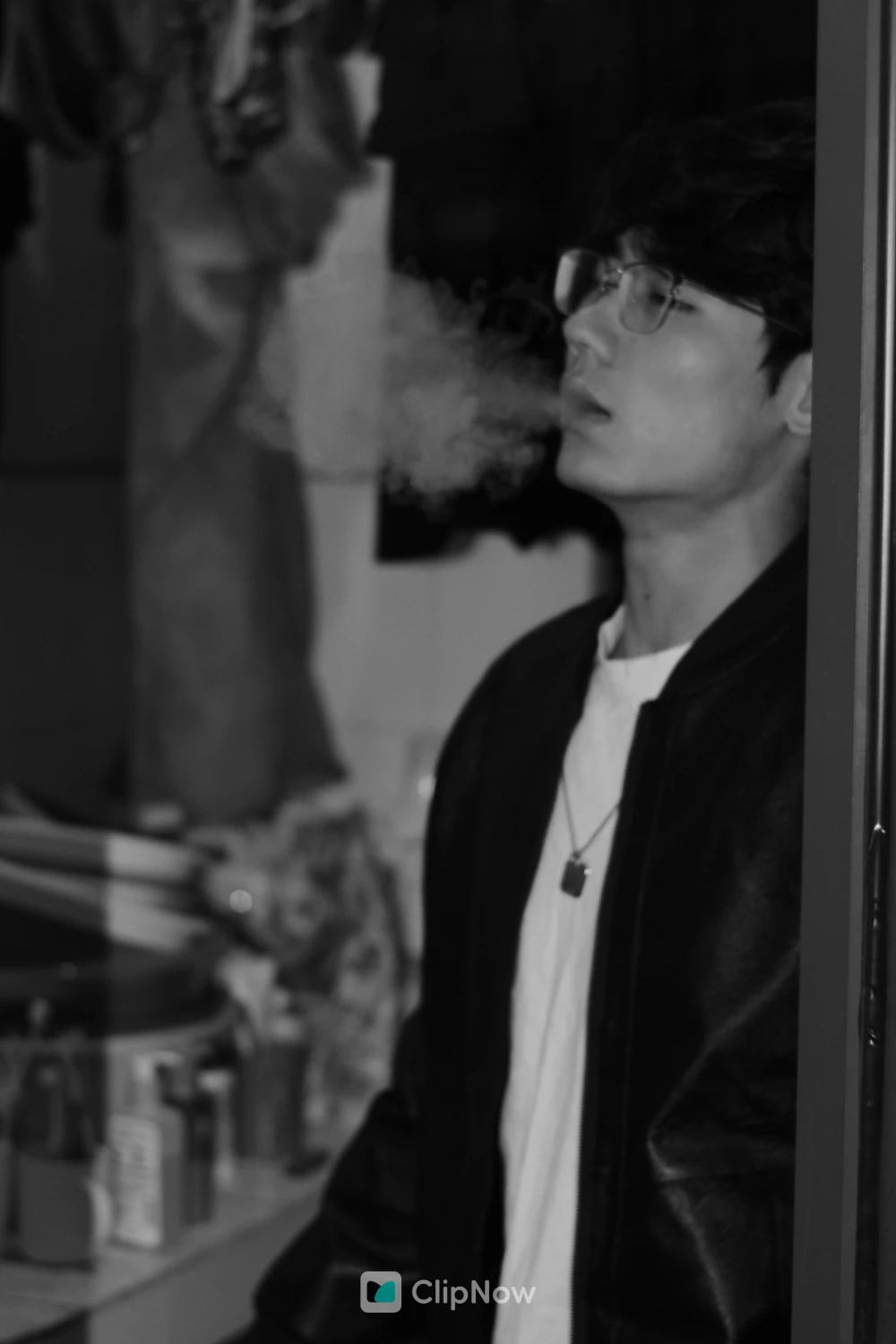戴眼镜年轻男子侧脸吐烟黑白情绪人像摄影