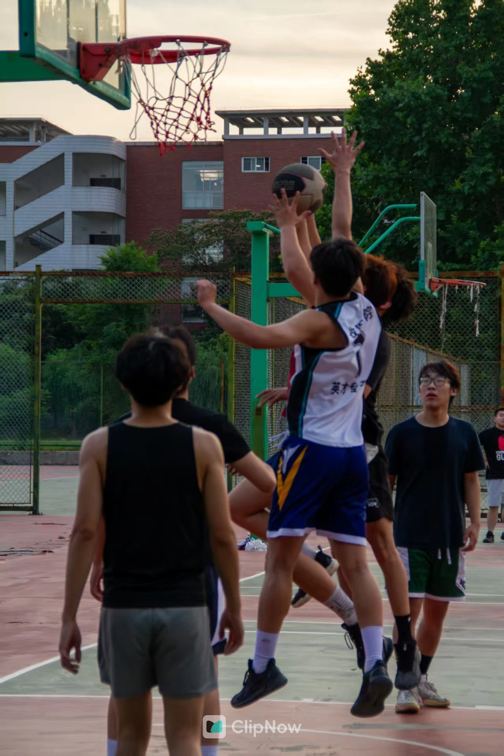 户外篮球场青少年激烈争抢篮板球瞬间
