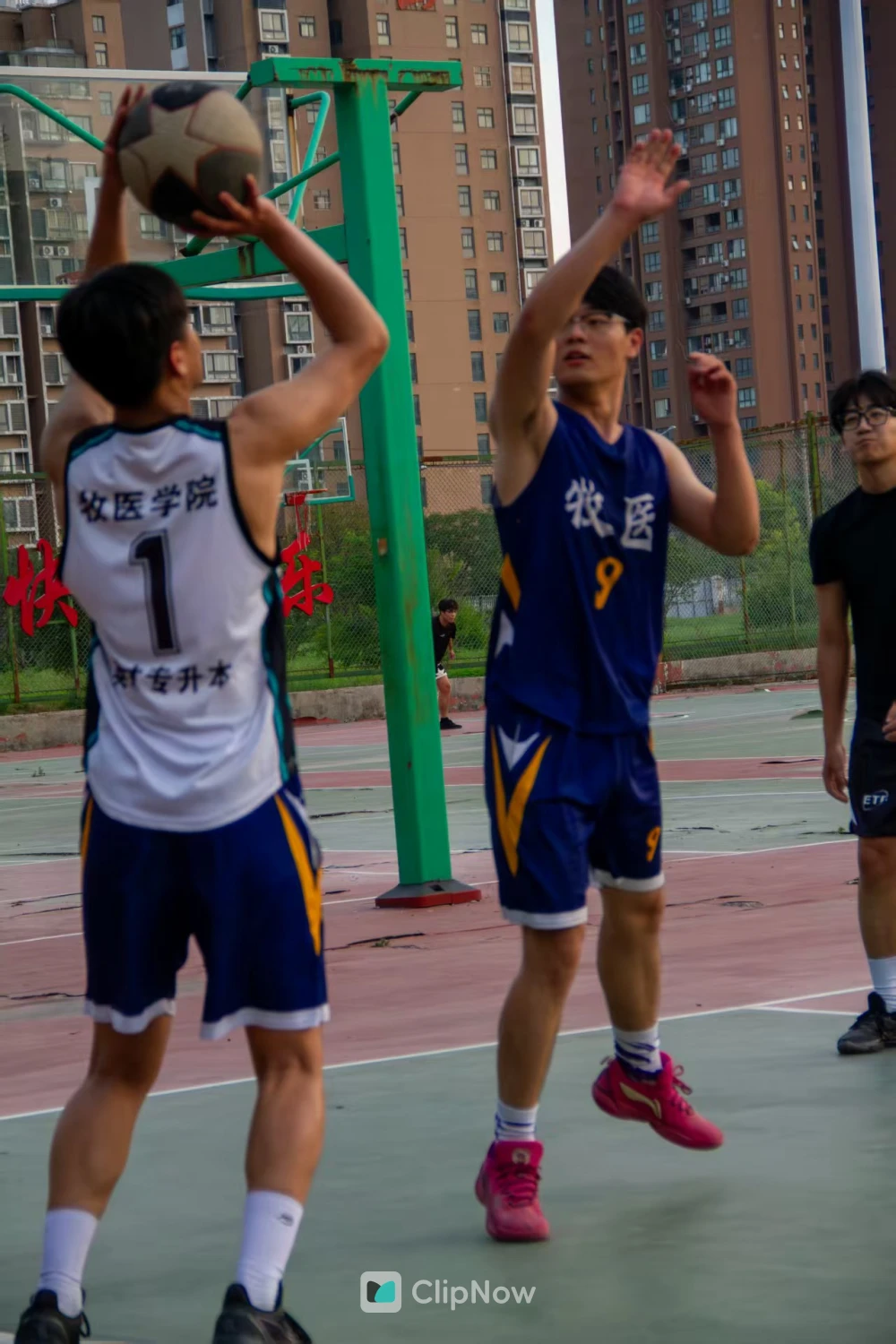 校园篮球场男生投篮防守竞技瞬间特写