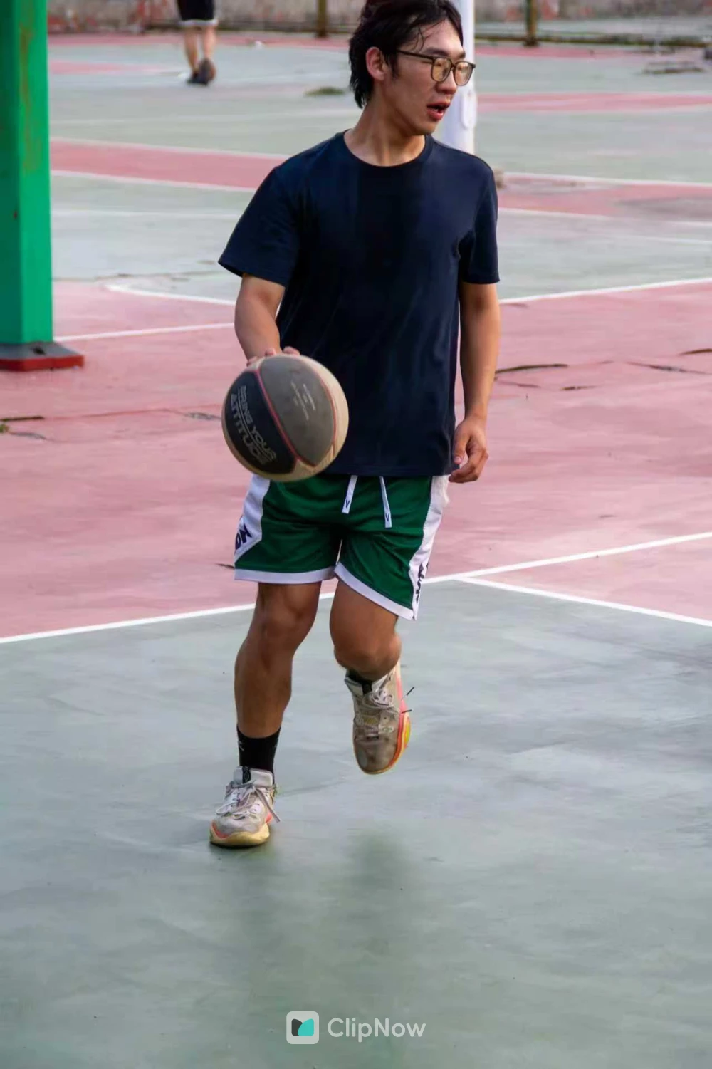 戴眼镜男子户外篮球场持球运球运动特写