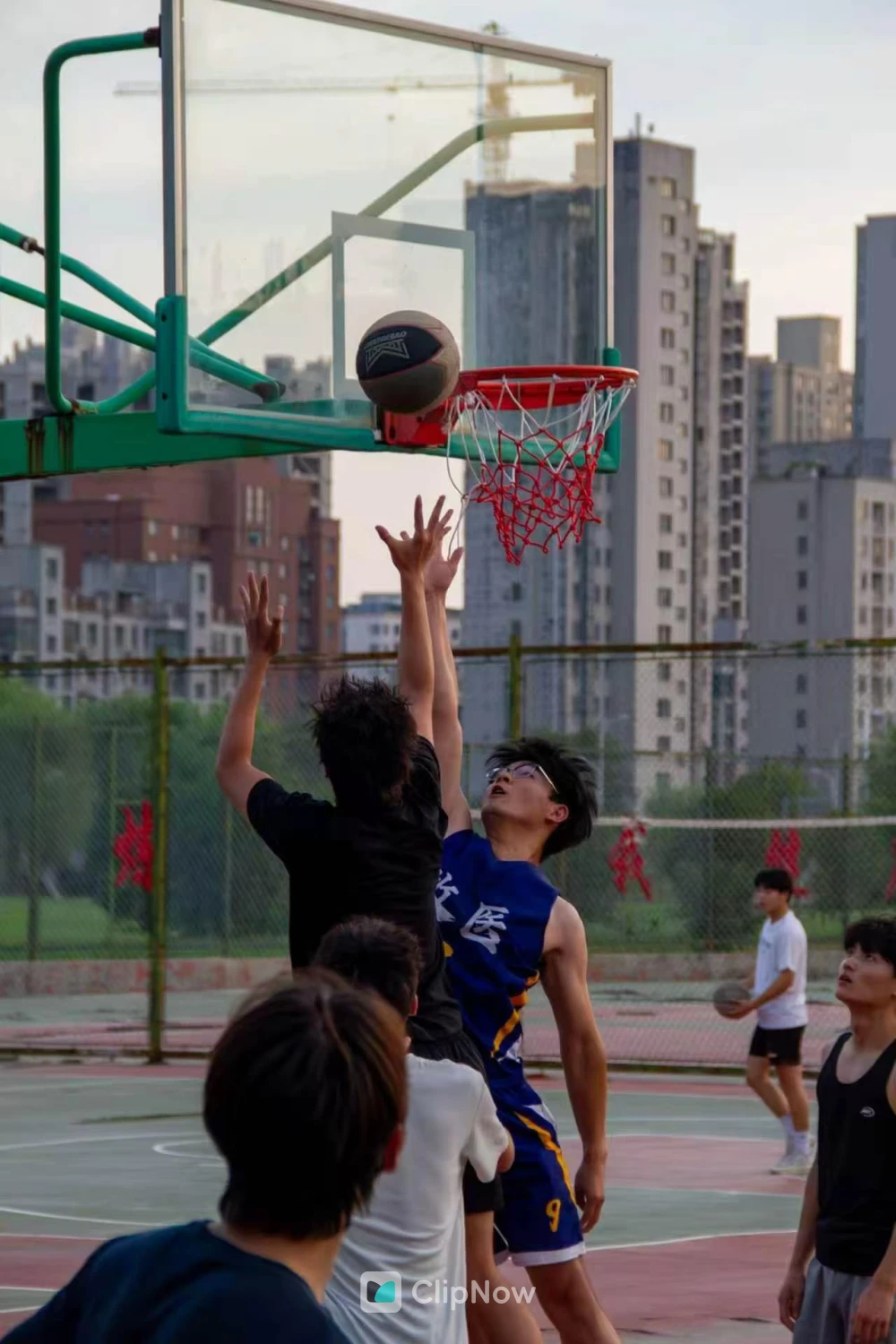 城市户外篮球场青年激烈争抢篮板球瞬间