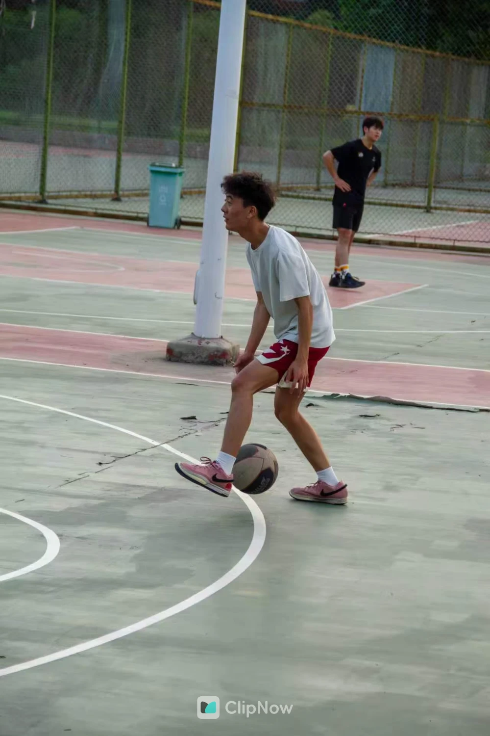 户外篮球场少年运球突破特写与粉色球鞋
