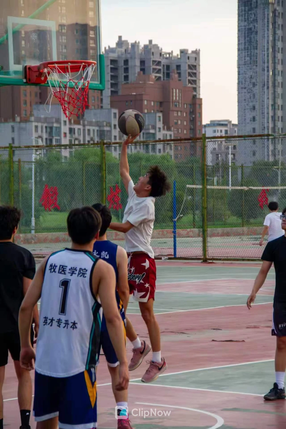 城市户外篮球场青年跃起上篮运动特写