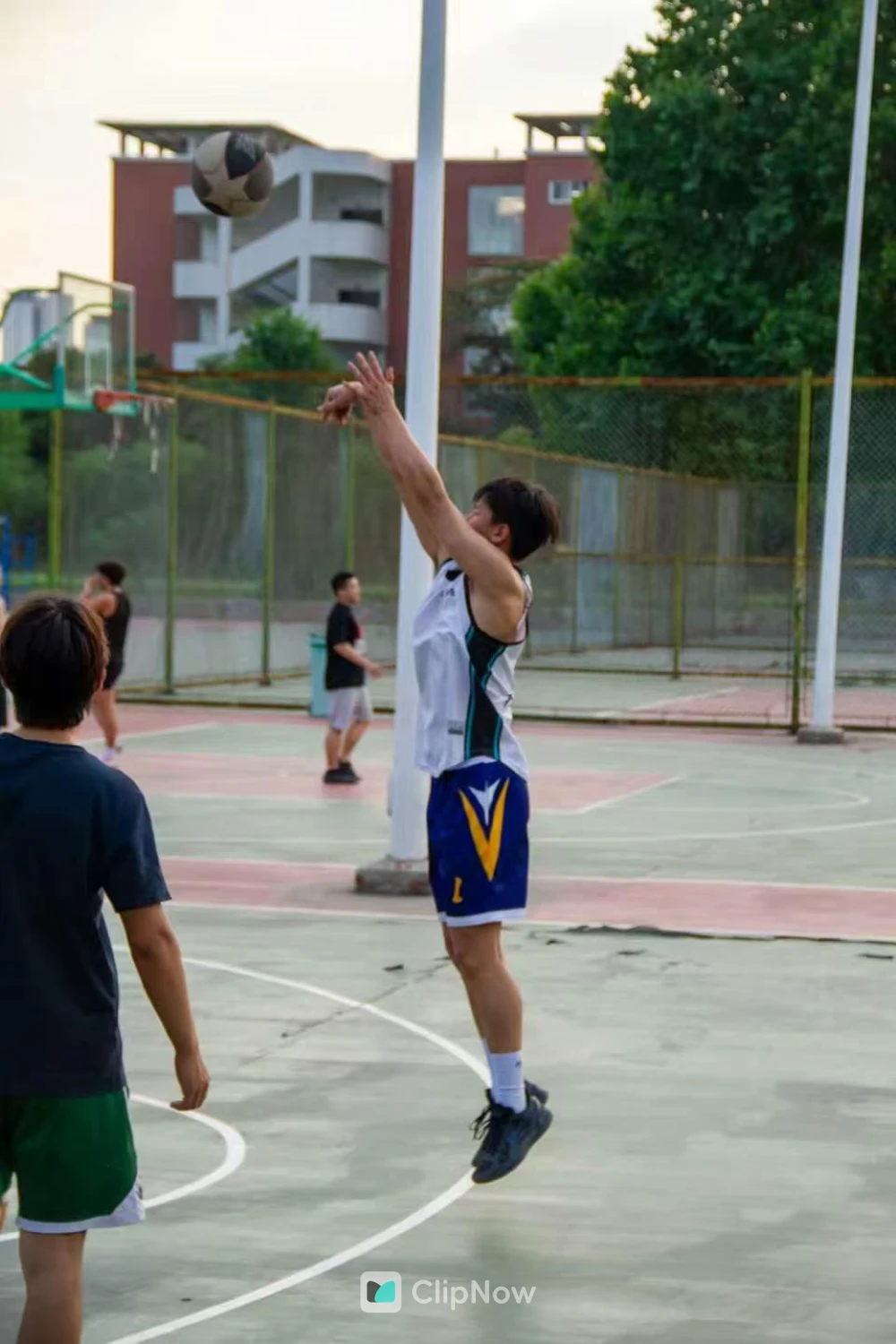 户外篮球场少年跃起投篮瞬间特写
