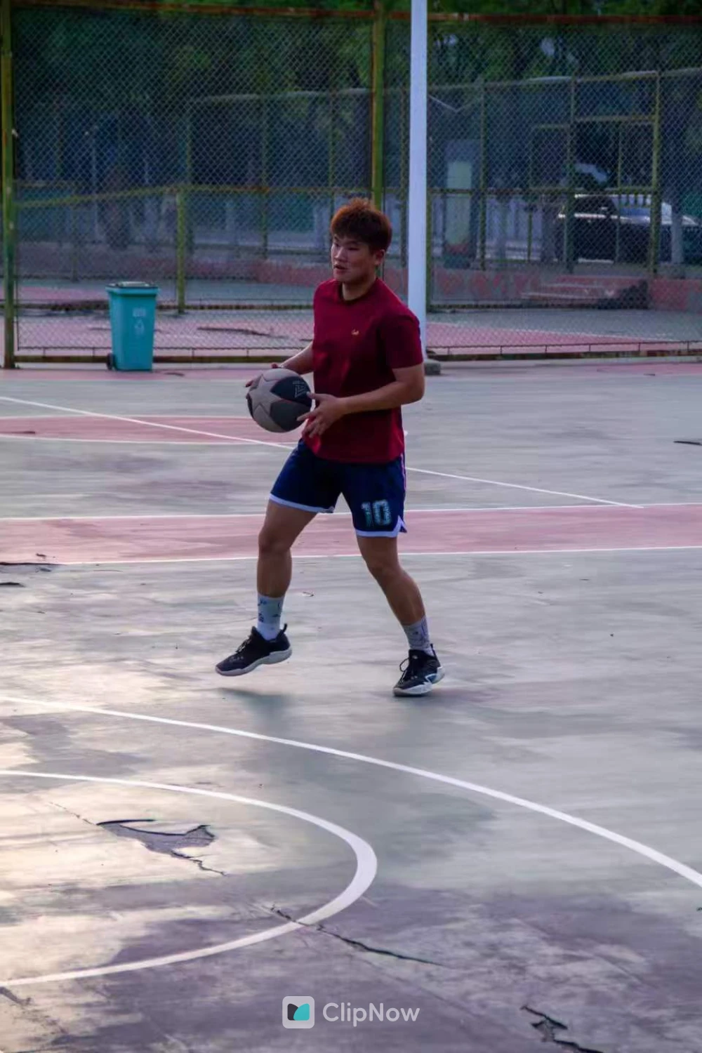 户外篮球场红衣少年持球运动瞬间特写