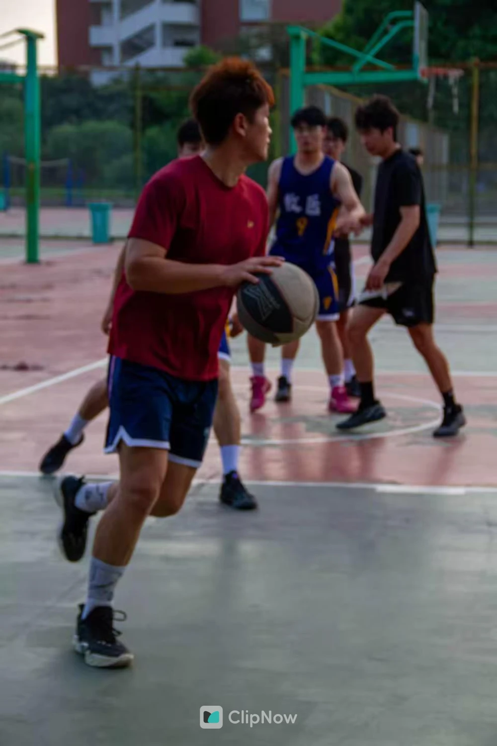 户外篮球场红衣少年持球突破运动瞬间