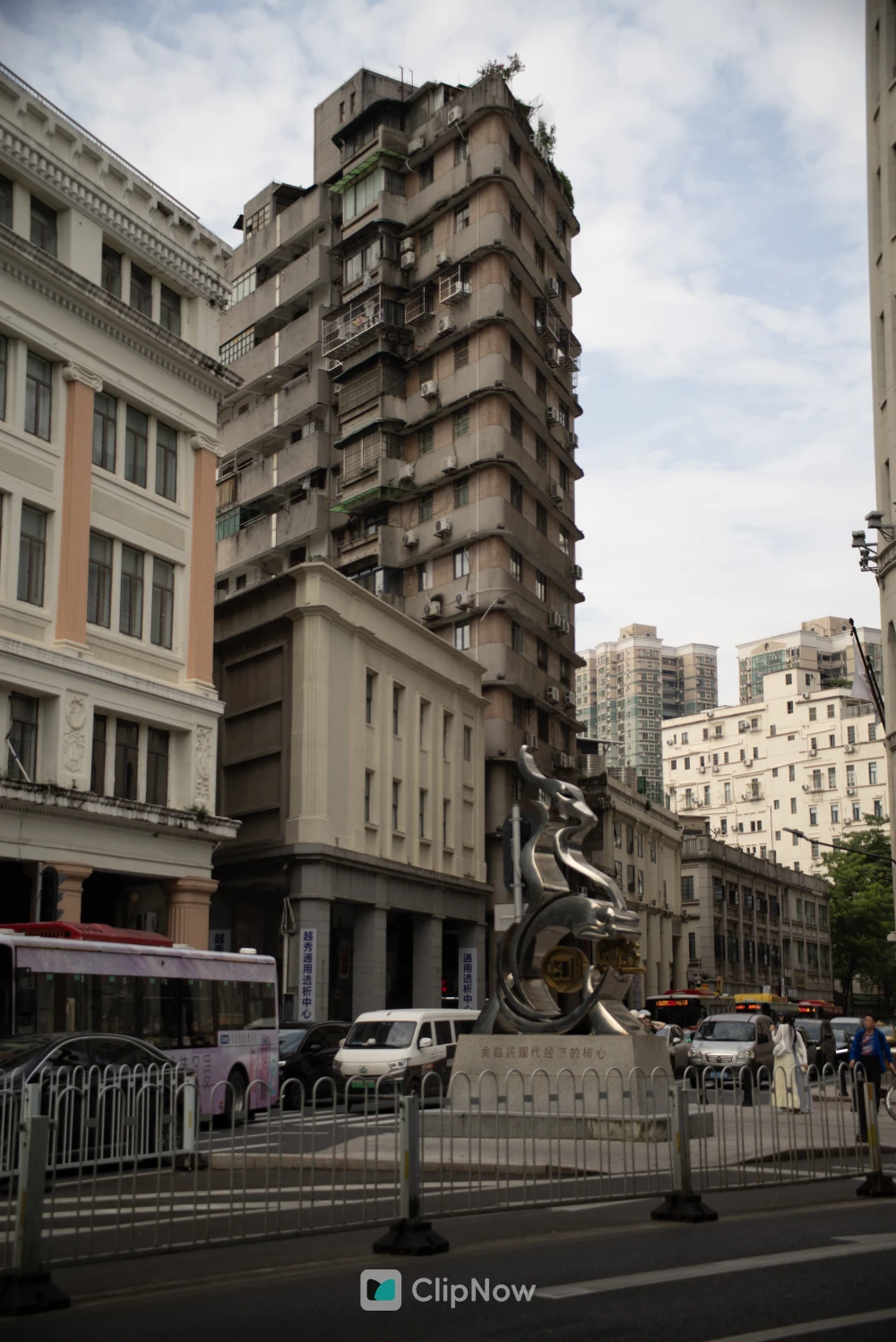 城市街景中银色龙形雕塑与现代建筑