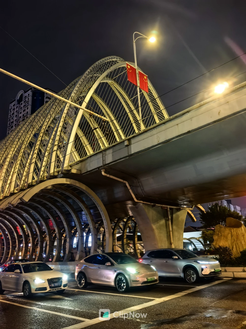 夜晚城市高架桥下行驶车辆与五星红旗风光摄影