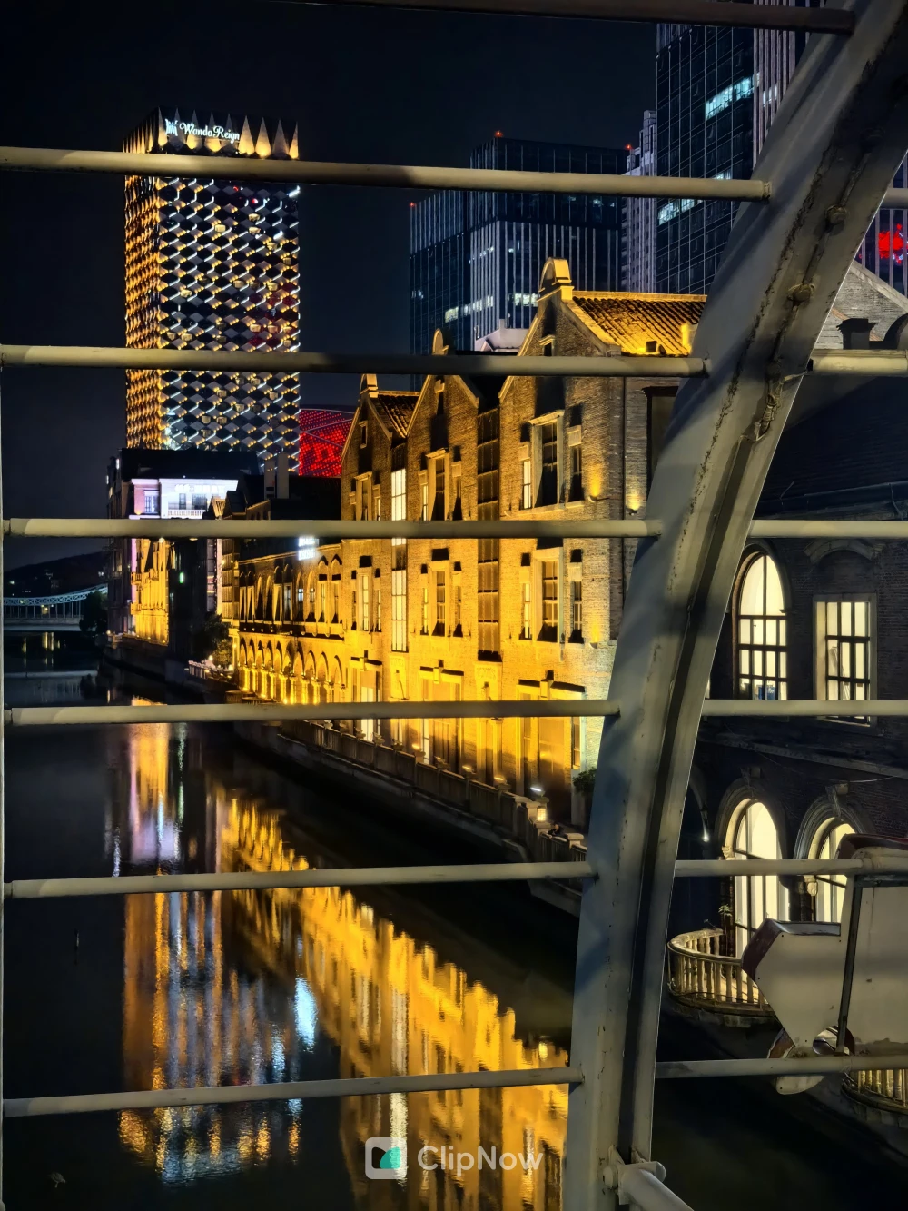 透过白色栏杆拍摄的夜景城市运河与复古建筑倒影