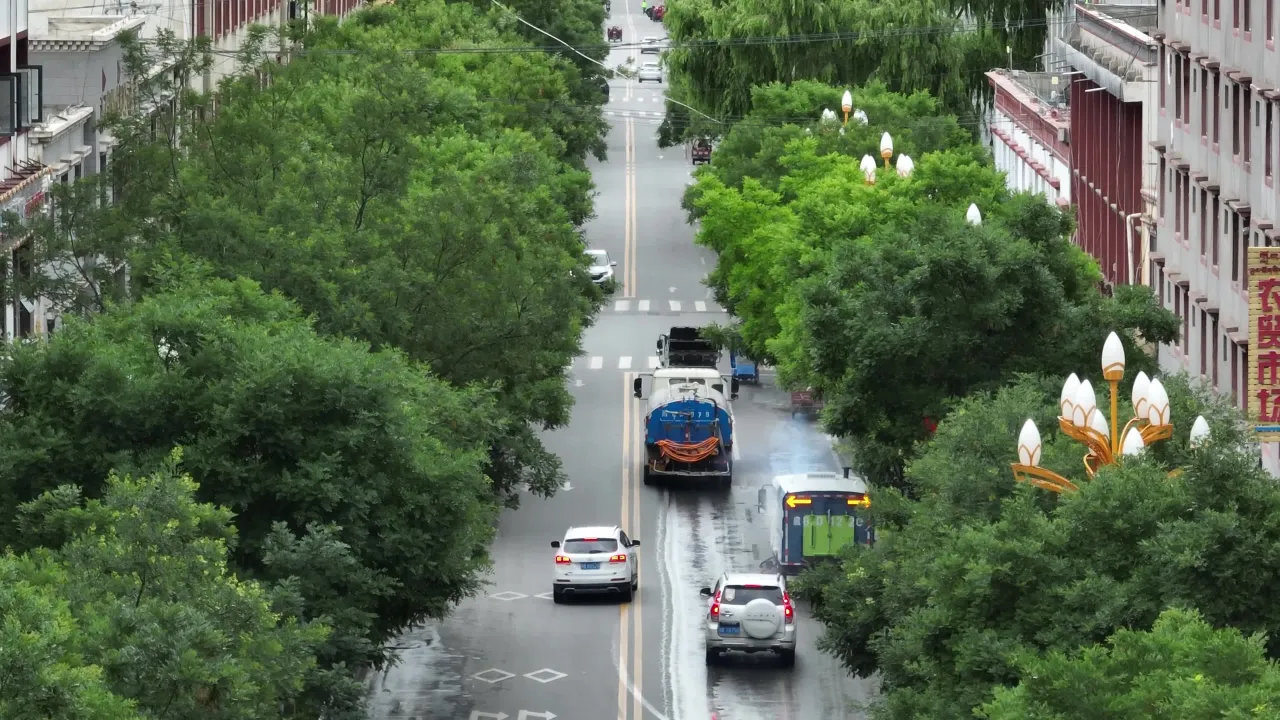 雨后城市街道洒水车作业航拍