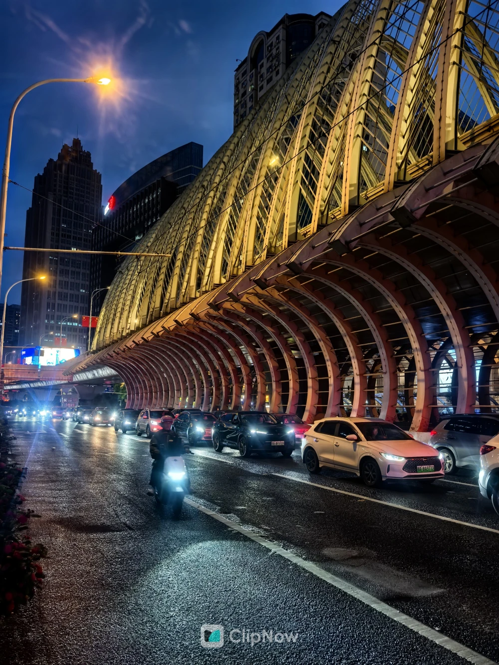 蓝调时刻城市夜景车流与拱形钢结构建筑摄影