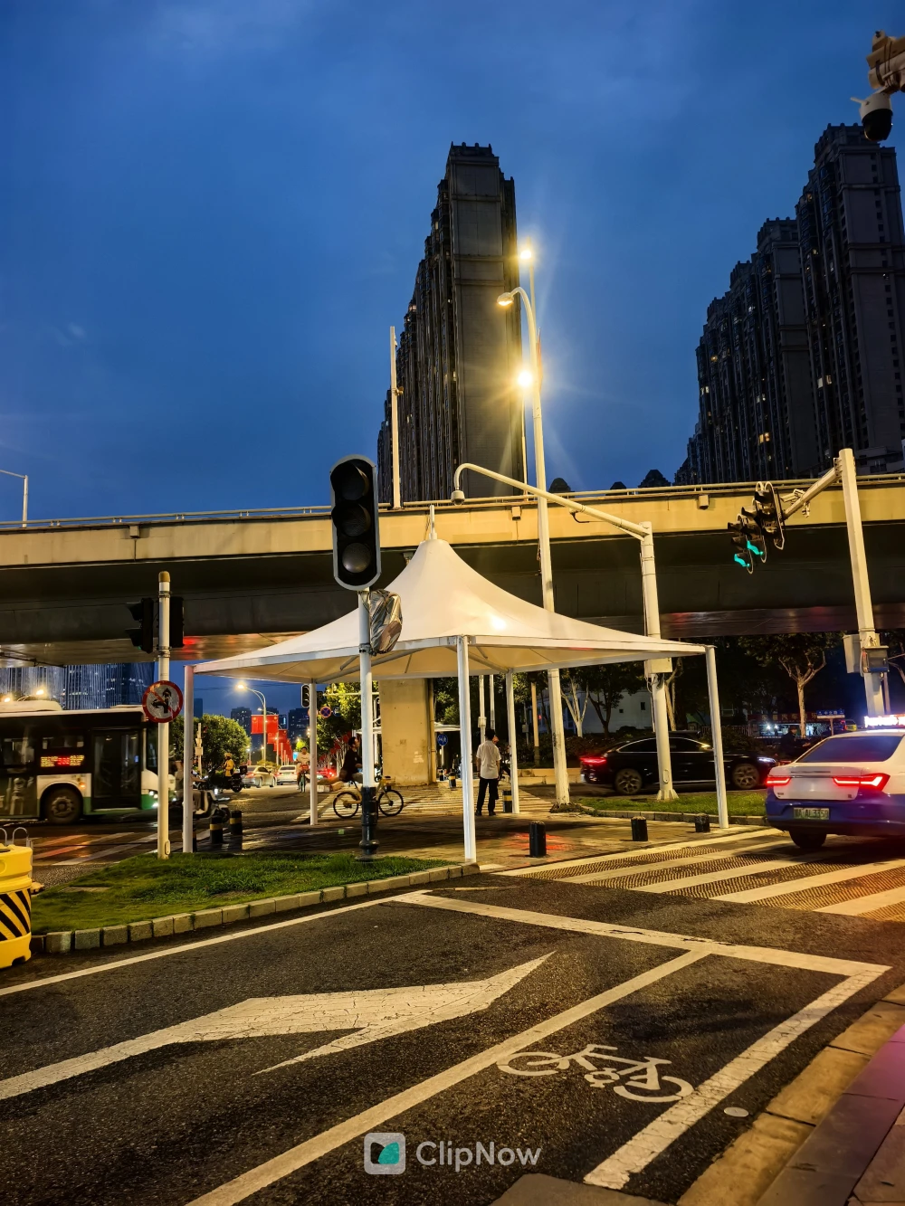 黄昏城市街头路口白色帐篷与高楼夜景摄影