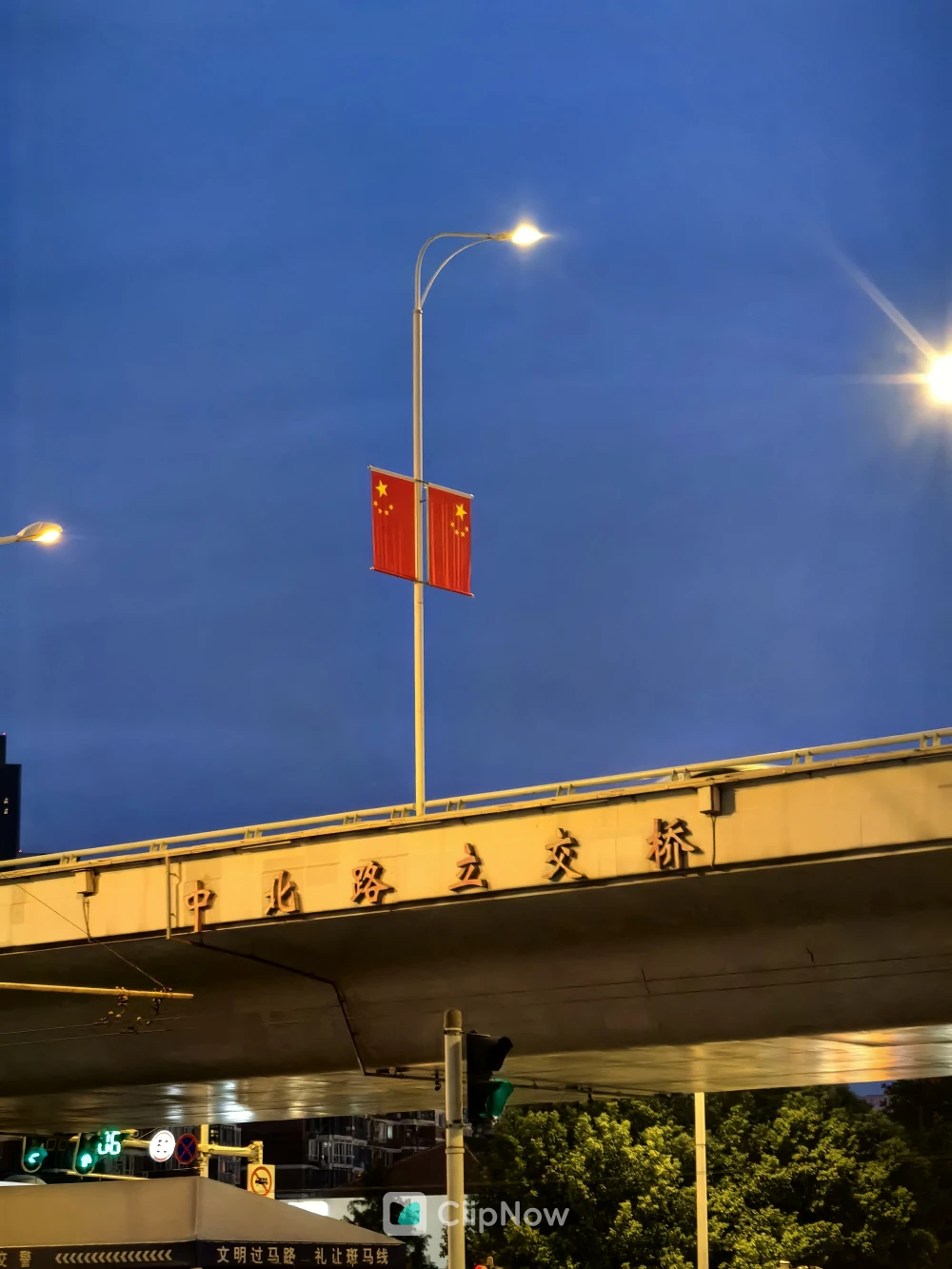蓝调时刻城市立交桥路灯悬挂五星红旗夜景摄影