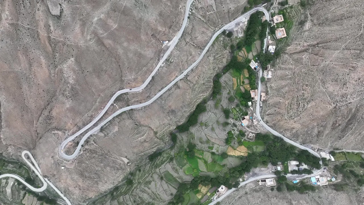 航拍蜿蜒盘山公路与河谷村庄