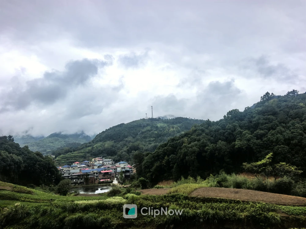 云雾缭绕的山区乡村风景与山顶信号塔